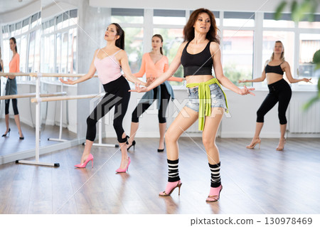 During lesson, woman learn to move and perform dance in heels with women companions 130978469