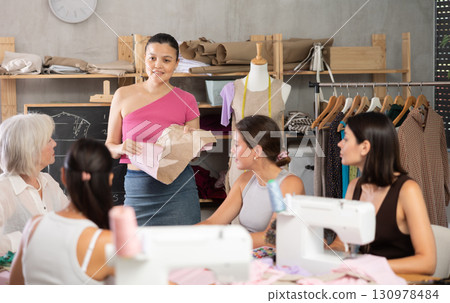 Young female teacher conducts master class on sewing 130978484