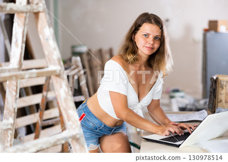 Seductive woman using laptop in apartment, home improvement works 130978514