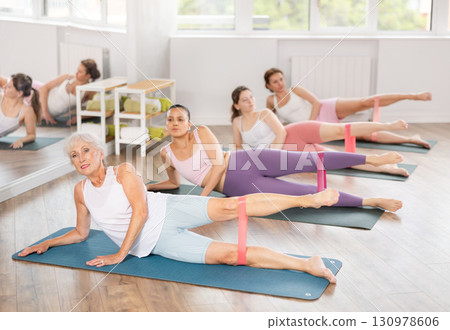 Elderly woman exercises with pilates band 130978606
