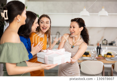 Group of women greeting each other and giving gift 130978607