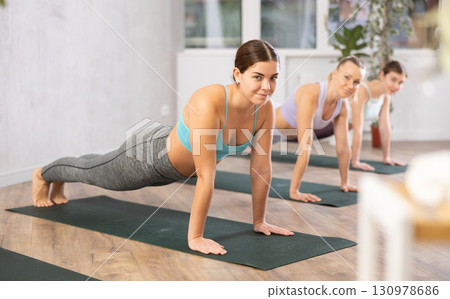 Three women doing fitness in fitness studio Three women doing fitness in fitness studio 130978686