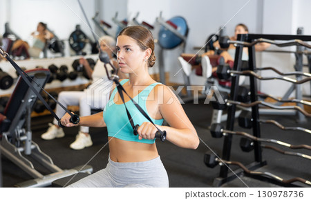 Young woman training with straps in gym Young woman training with straps in gym 130978736