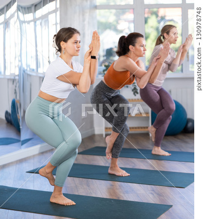 Girl performing Garudasana or Eagle Pose at group yoga class 130978748