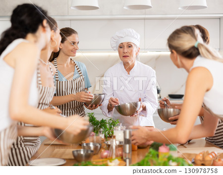 Elderly woman teaching cooking to group of woman 130978758