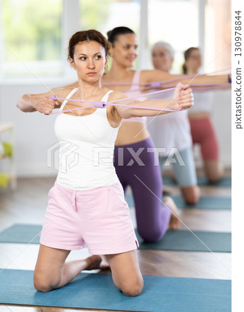 Woman using figure eight resistance band for exercise during training Woman using figure eight resistance band for exercise during training 130978844