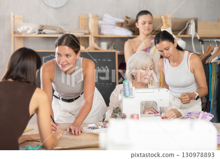 Group of happy attendees of dressmaking courses engaged in different activities Group of happy attendees of dressmaking courses engaged in different activities 130978893