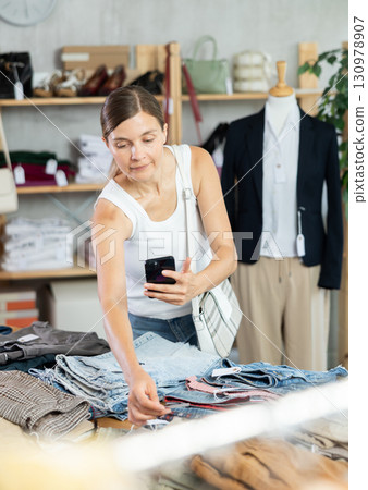 Adult woman scanning qr code of trousers in clothing store Adult woman scanning qr code of trousers in clothing store 130978907