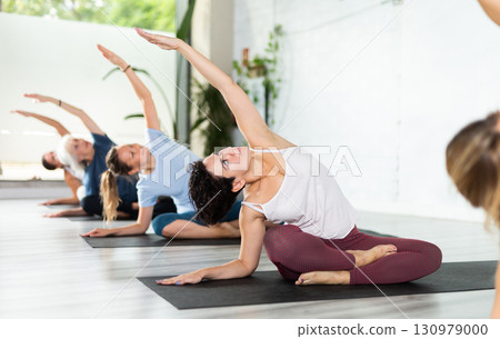 Women practicing yoga - virabhadrasana pose 130979000