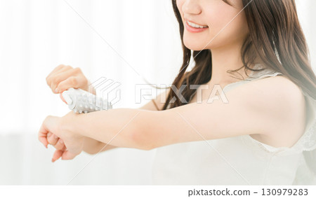 Young asian woman using massage roller on arm at home Young asian woman using massage roller on arm at home 130979283