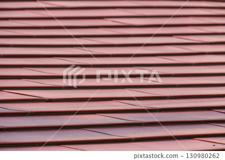 Close-up of a brick-colored metal roof. Metal texture for background. 130980262