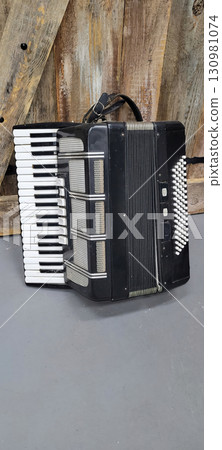 A Vintage Black Accordion with striking White Keys and an intricate Musical Design A Vintage Black Accordion with striking White Keys and an intricate Musical Design 130981074