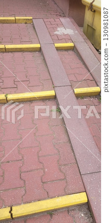 A Colorful Paved Walkway with Safety Markings Designed for Accessibility and Aesthetic Appeal 130981087