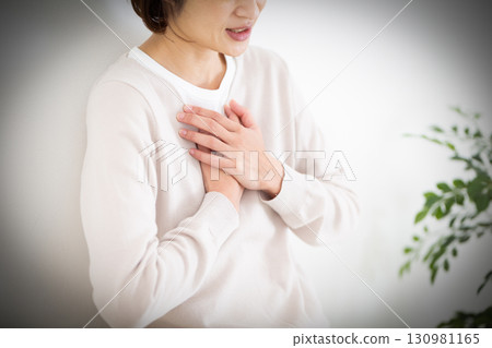 Middle woman suffering from chest pain 130981165