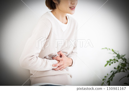 Middle-aged woman suffering from stomach pain Middle-aged woman suffering from stomach pain 130981167