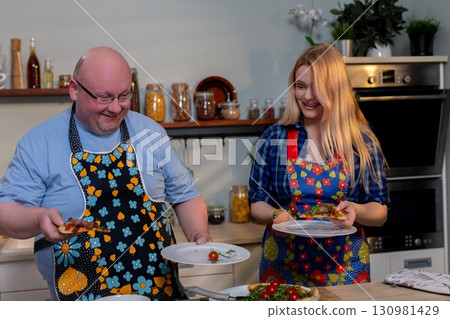 Enjoying a joyful cooking moment in a bright kitchen filled with colorful aprons Enjoying a joyful cooking moment in a bright kitchen filled with colorful aprons 130981429