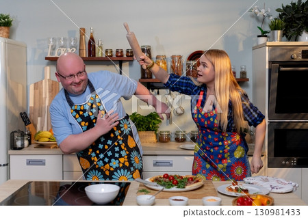 Enjoy watching this fun and lively cooking duo as they share playful moments in the kitchen Enjoy watching this fun and lively cooking duo as they share playful moments in the kitchen 130981433