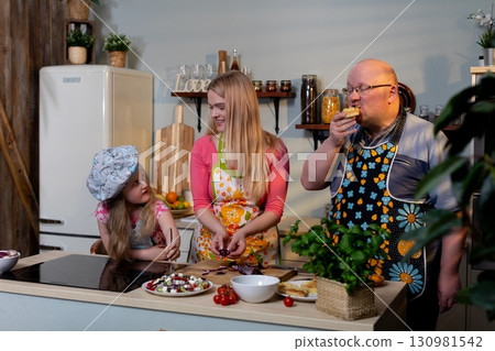 Cooking together as a family in a vibrant modern kitchen can be a joyful and fun experience Cooking together as a family in a vibrant modern kitchen can be a joyful and fun experience 130981542