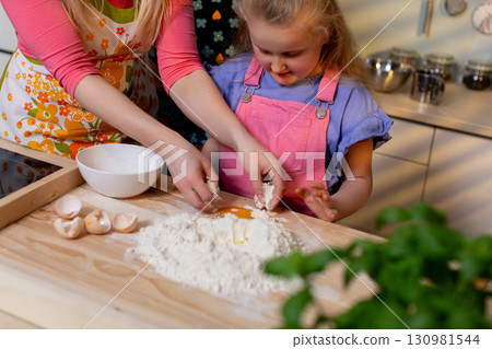 Cooking Together as a Family A Parent and Child Creating Homemade Dough in the Kitchen Cooking Together as a Family A Parent and Child Creating Homemade Dough in the Kitchen 130981544
