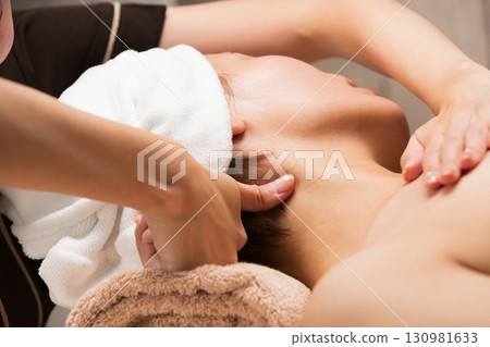 A young Asian woman is getting a neck massage. 130981633
