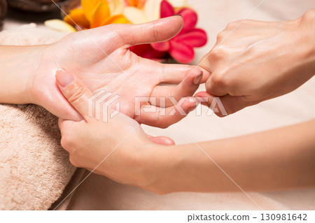 A young Asian woman is getting a hand massage. 130981642