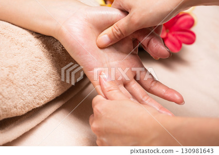 A young Asian woman is getting a hand massage. 130981643