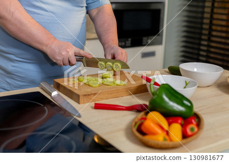 Chopping and Preparing Fresh Vegetables in a Stylish and Modern Kitchen Environment Chopping and Preparing Fresh Vegetables in a Stylish and Modern Kitchen Environment 130981677