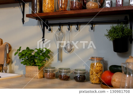 A warm and cozy kitchen filled with fragrant herbs and jars of various ingredients A warm and cozy kitchen filled with fragrant herbs and jars of various ingredients 130981708