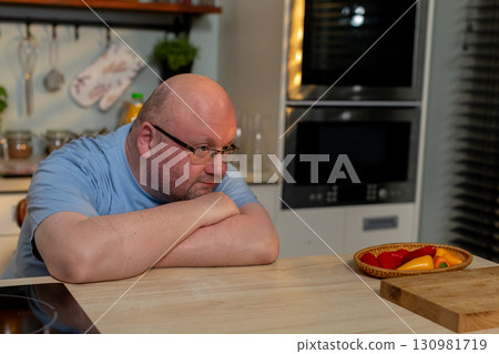 A skilled chef thoughtfully engaging with fresh ingredients in a modern kitchen, preparing a meal 130981719