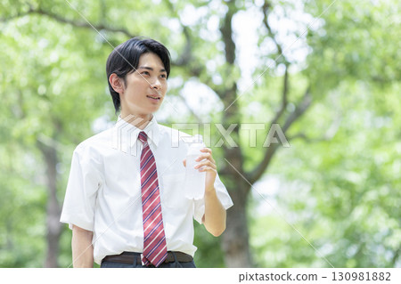 A male high school student drinking a sports drink 130981882