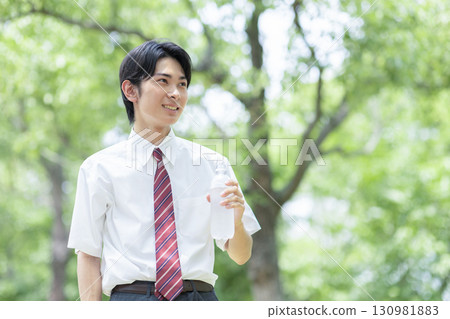 A male high school student drinking a sports drink 130981883