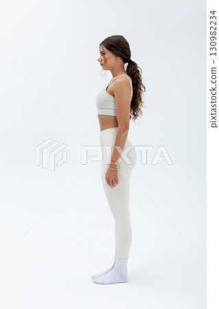Showcasing a Trendy Athletic Pose within a beautifully Minimalistic Fashion Setting 130982234