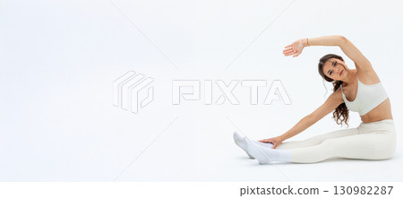 A woman in white athleisure stretches in a minimalist background, embodying calm and wellness A woman in white athleisure stretches in a minimalist background, embodying calm and wellness 130982287