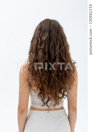 A Stunning Display of Beautiful Curly Hair Styled in a Fashionable Pose and Attitude 130982319