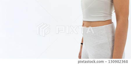 A fashionable woman is showcasing stylish athleisure wear against a clean white background A fashionable woman is showcasing stylish athleisure wear against a clean white background 130982368