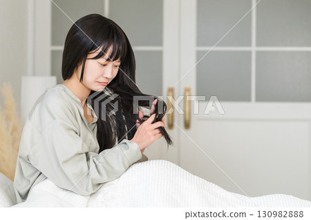 Women who suffer from damaged hair caused by friction from pillows, tangled hair, dryness, and brittleness 130982888