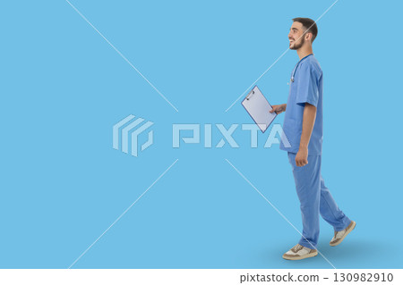 Doctor engages in a professional activity while wearing scrubs 130982910