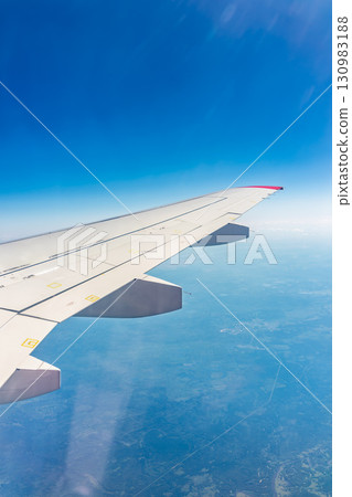 View from the airplane window at a beautiful blue clear sky and the airplane wing 130983188