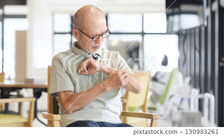 亞洲老年男子因皮膚病抓手臂 130983261