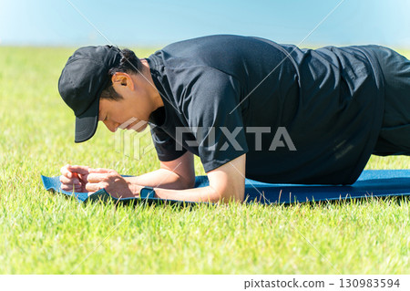 公園進行肌力訓練,中年男子做平板撐 公園進行肌力訓練,中年男子做平板撐 130983594