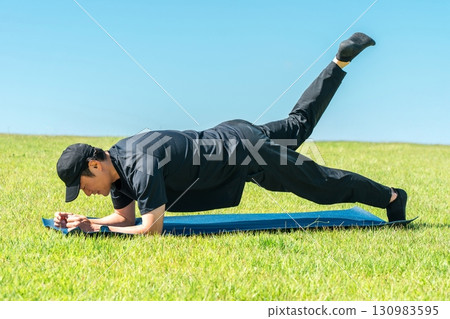 一名男子在公園裡做瑜珈/皮拉提斯（運動、健身、瑜珈、運動、伸展運動） 130983595