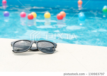 Sunglasses placed by the pool (tropical, vacation) 130983797
