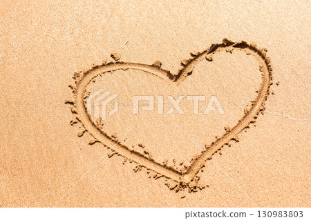 Heart symbol written on the sea sand 130983803