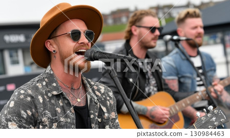 Live Music Performance Outdoors with Singer and Guitarists Playing 130984463
