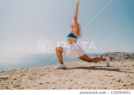 Woman Practicing Yoga on a Cliff with Ocean View 130984601