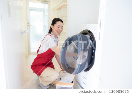 Cleaning, housekeeping, middle-aged woman doing laundry 130985625