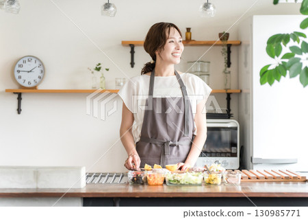 年輕的亞洲女人在廚房做飯（切菜、用刀、烹飪、家常菜） 130985771