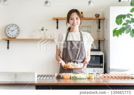 A housewife serving a one-plate lunch in the kitchen A housewife serving a one-plate lunch in the kitchen 130985773
