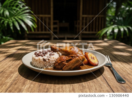 Traditional Belizean stew chicken with rice and beans served in a tropical jungle setting 130986440