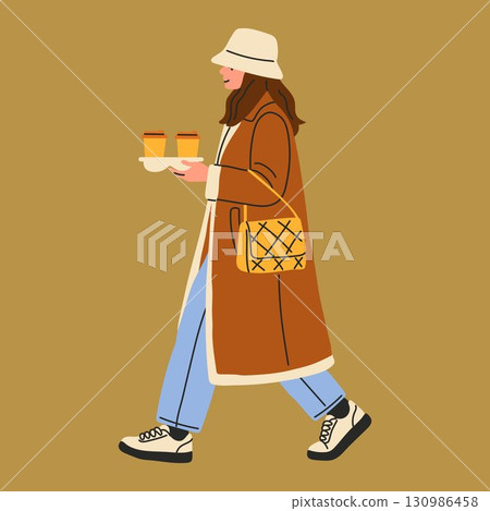 Woman Carrying Two Cups of Coffee in Winter Outfit 130986458